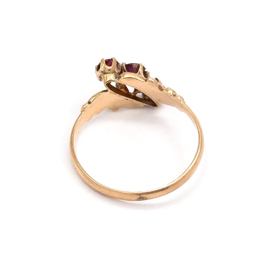 Seen from behind and above, the open gallery and prong tips sit at the top while the slender rose gold shank sweeps down in a full circle.