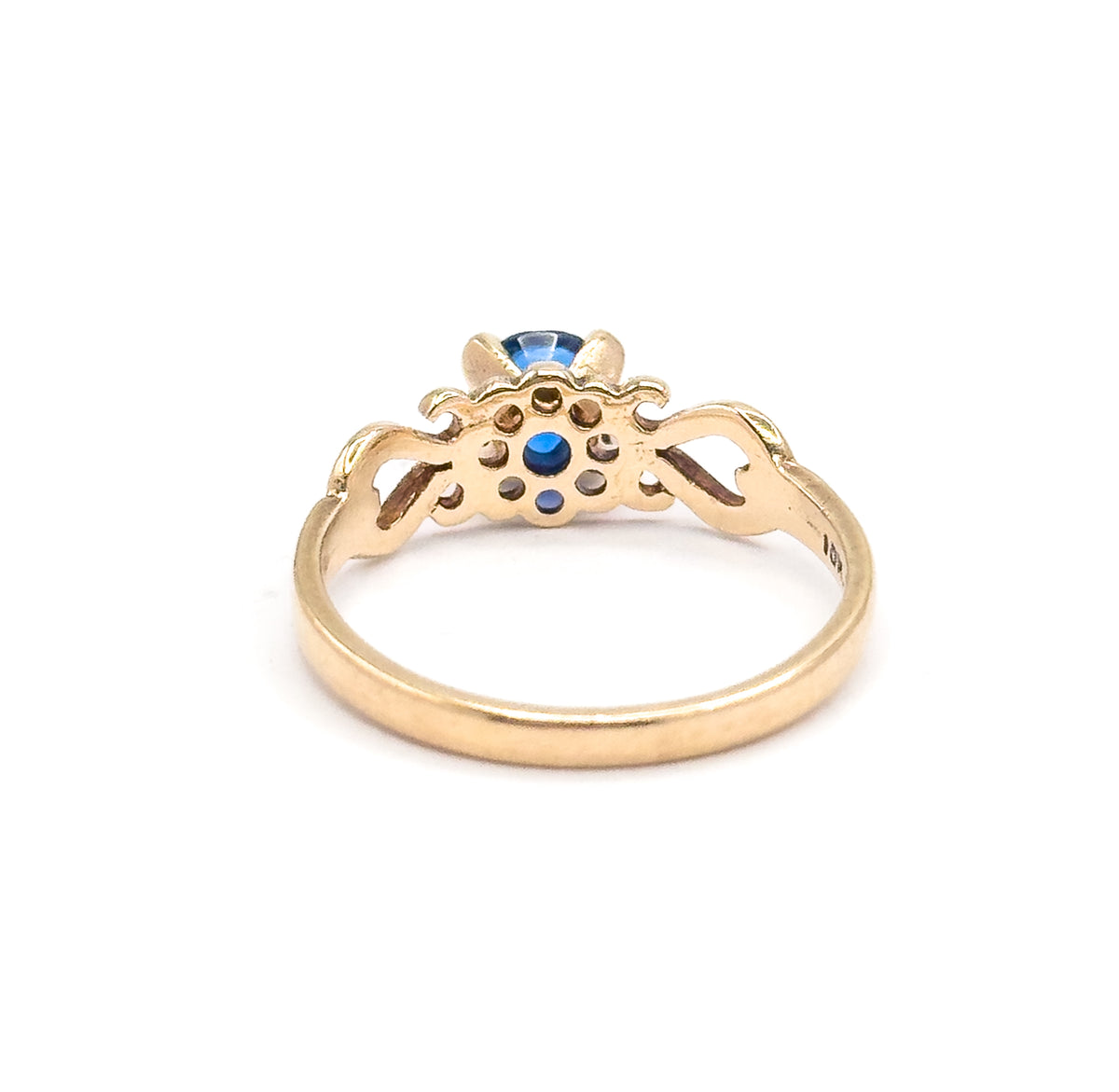 Another rear view, tilted lower so the cobalt spinel peeps over the top of the open gallery and the pierced scrolled shoulders flank it on either side of the yellow gold shank.