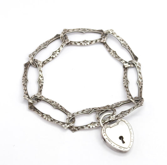 Almost the same view with slightly different angle, the ring of links tipped slightly forward so the heart lock clasp sits nearer the viewer, its keyhole and banded edge clearly shown.