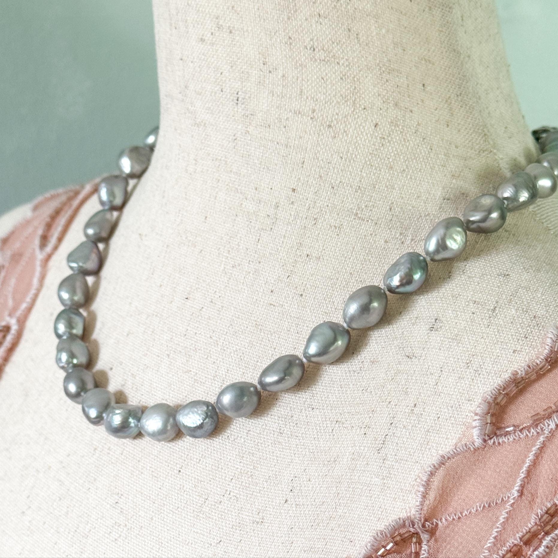 Gray pearl necklace on a mannequin with a light background