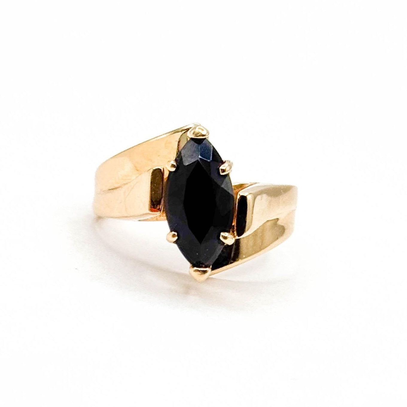 Gold ring with a black gemstone on a white background