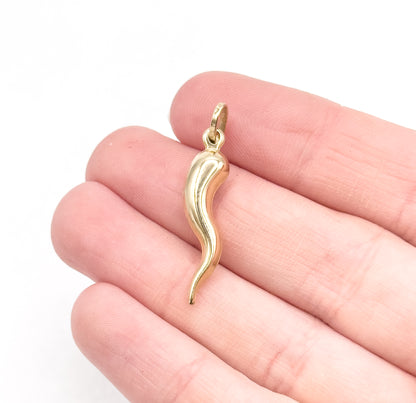 Resting across three fingers for scale, the yellow gold cornicello spans a little more than the width of two fingers, its bale sitting at the fingertip end.