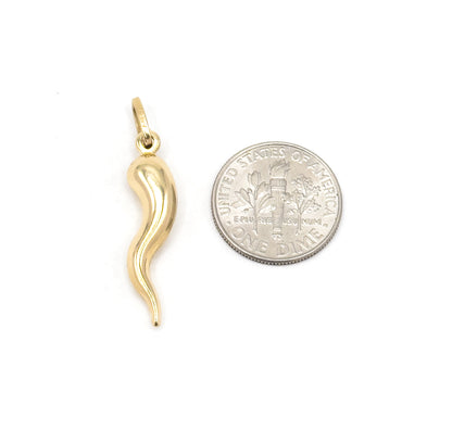 Laid beside a US dime on white, the yellow gold cornicello stands roughly one and a half times the coin's diameter in length, with the bale rising above its curved top.