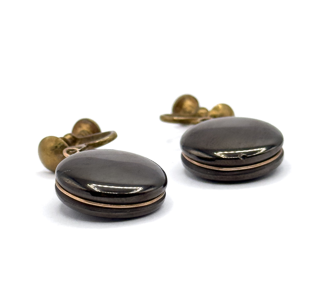 Both earrings seen from the side on a white ground, showing the domed profile of each anthracite disc with a fine rose gold filled wire running around its rim and the ball screw backs behind.