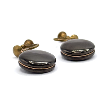 Both earrings seen from the side on a white ground, showing the domed profile of each anthracite disc with a fine rose gold filled wire running around its rim and the ball screw backs behind.