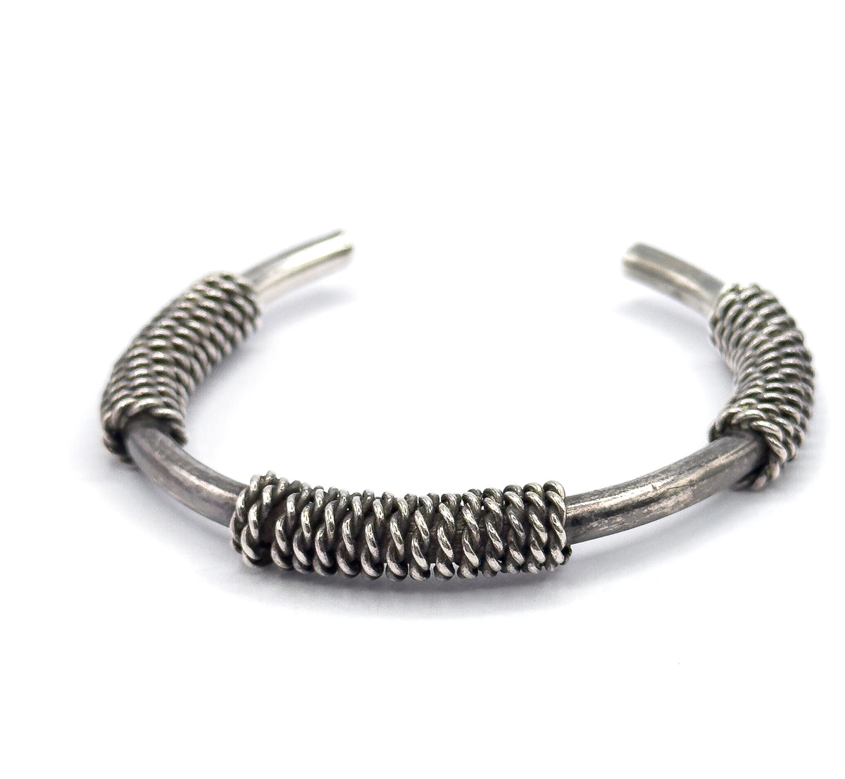 Front-on view at eye level with the broad central coil filling the foreground and the sterling silver band arching up and away to the two tapered terminals splayed at the top.