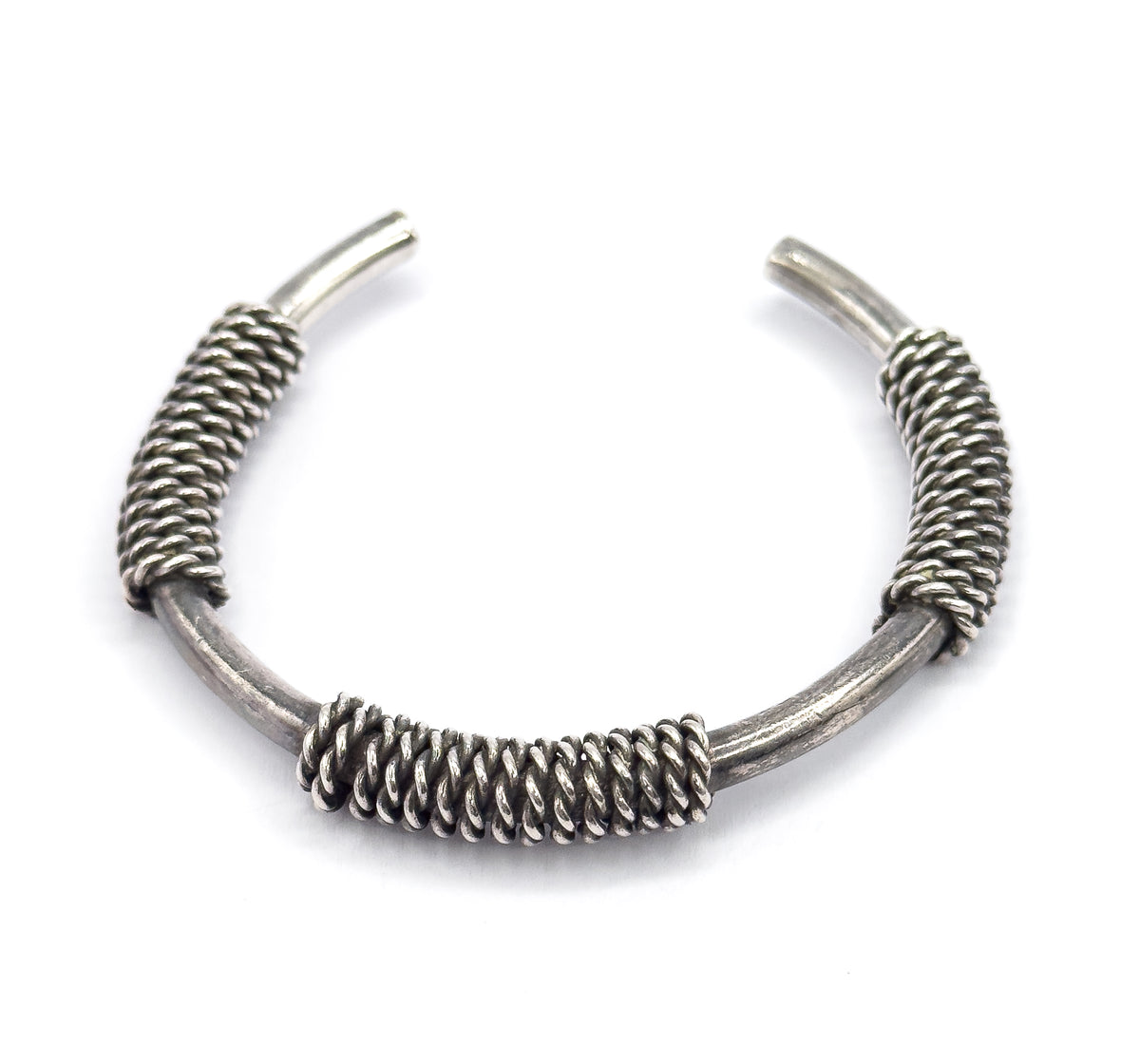 Overhead view with the opening uppermost, the central coil now at the bottom of the arc and the two tapered terminals pointing up and apart, patina dark between the twisted strands.