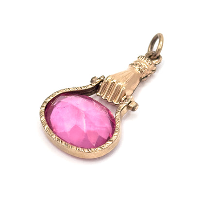 Angled with the stone at lower left, the raspberry pink glass reads almost face-on inside its engraved bezel while the ribbed fingers, cuff collar and suspension ring step up to the right.