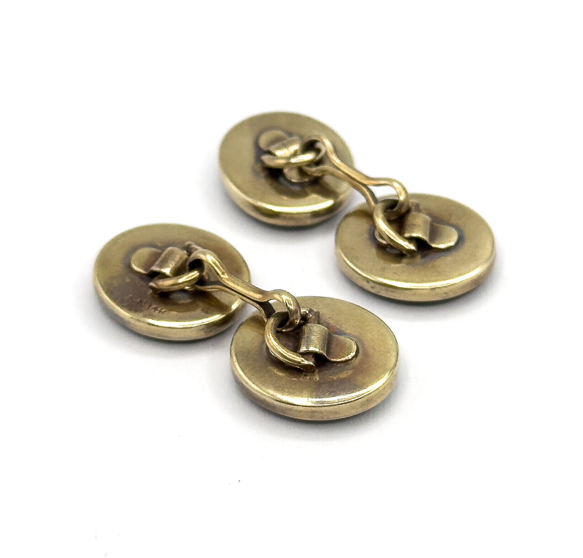 Both cufflinks together from the reverse, all four plain oval yellow gold backs and their curved link bars angled towards the viewer.