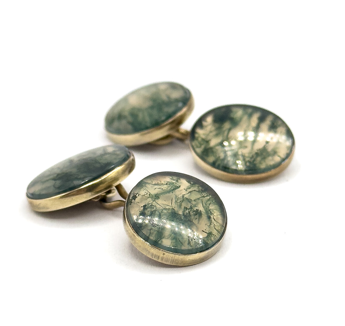 Both cufflinks stood at eye level against white, the four moss agate faces catching light so their green veining and low bezel walls read from the side.