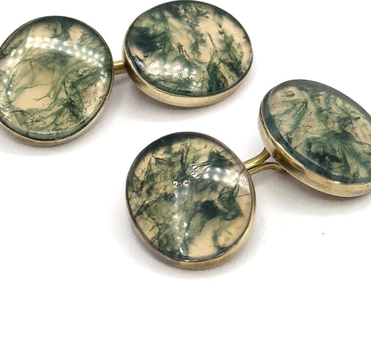 Close overhead view filling the frame with all four moss agate faces, their deep green veining and cream ground clear inside the yellow gold bezel rims, link bars joining each pair.