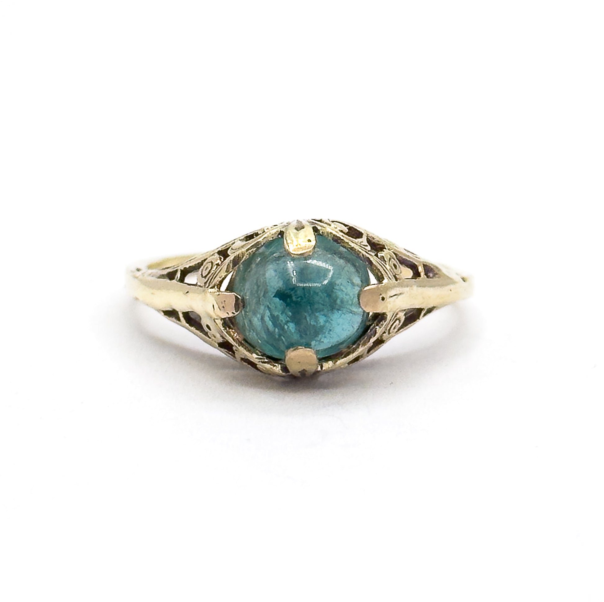 Straight-on view from directly above the ring lying flat, the round greenish blue cabochon centred between four prongs with the pierced fern gallery spreading symmetrically to each shoulder.