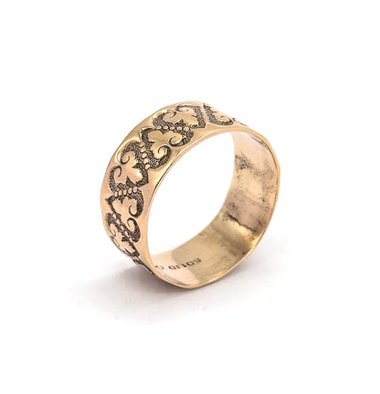 Tilted so the ring's interior is visible, the smooth inside of the shank curving away with stamped lettering reading upside down along its lower edge.