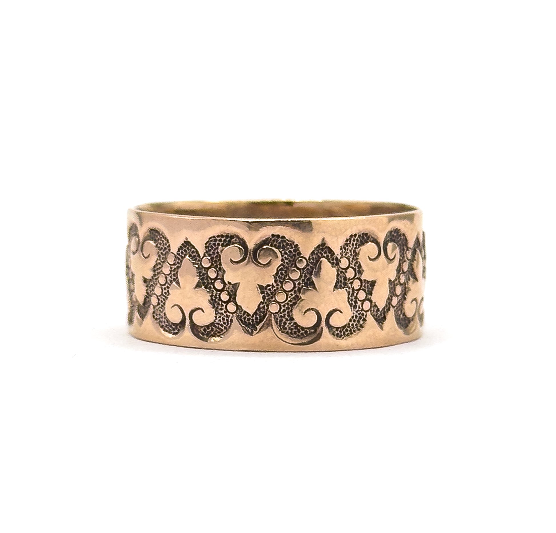 Centred against a plain white background, the wide band fills the frame with its dark stippled recesses throwing the smooth hearts and beaded scrolls into relief across the front of the shank.