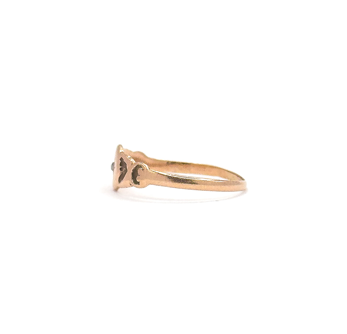 Side profile at eye level, showing how low the star-set face sits above the finger, with pierced scrollwork at the shoulder where the band widens into the setting.