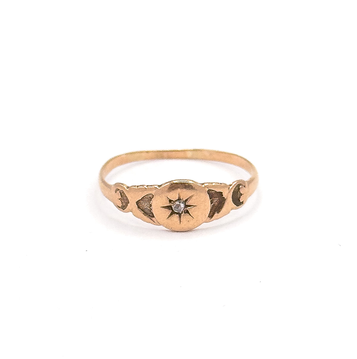 Standing upright and facing the camera, the rose gold face is centred with the rose cut diamond in its engraved star, flanked by darkened scroll motifs along both shoulders.