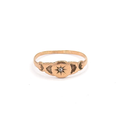 Standing upright and facing the camera, the rose gold face is centred with the rose cut diamond in its engraved star, flanked by darkened scroll motifs along both shoulders.