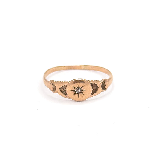 Standing upright and facing the camera, the rose gold face is centred with the rose cut diamond in its engraved star, flanked by darkened scroll motifs along both shoulders.