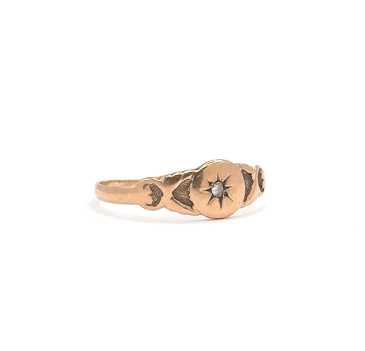 Victorian rose cut diamond star ring in 10K rose gold, shown upright side-on against white, the tiny diamond set in an engraved star at the centre of the shaped, tapering band.
