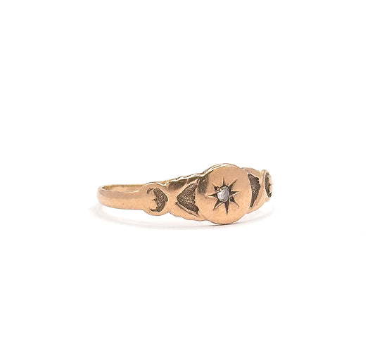 Victorian rose cut diamond star ring in 10K rose gold, shown upright side-on against white, the tiny diamond set in an engraved star at the centre of the shaped, tapering band.