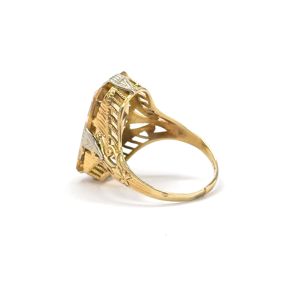 Profile view off the hand against plain white, showing the setting's height above the slim shank and the pierced arcaded gallery supporting the citrine from the side.