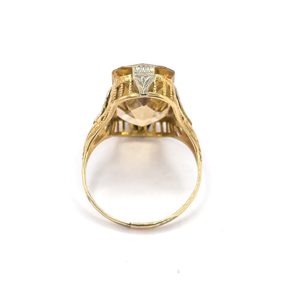 End-on view looking straight through the shank's open circle, so the underside of the citrine, the arcaded gallery bars and one white gold prong are seen from beneath.