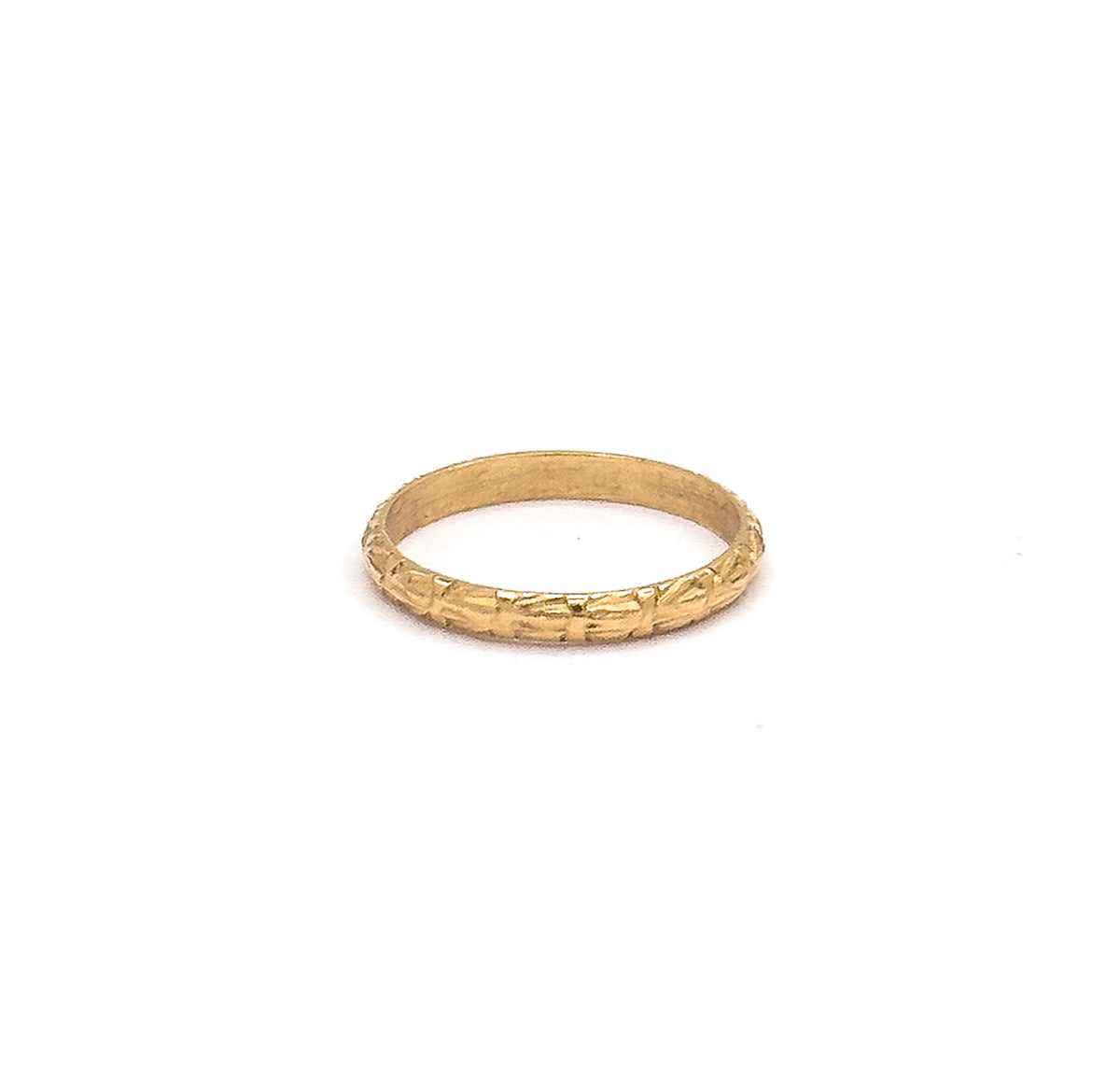 Set small within a wide white frame that conveys how tiny the ring is, the band tilts just enough to show the chased front edge and the plain inner wall behind it.