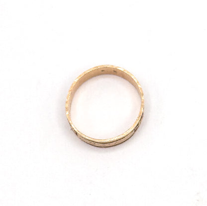 The hoop lies flat against white, seen through the open circle so the inner shank and the narrow outer edge of the clover-engraved band are both visible.