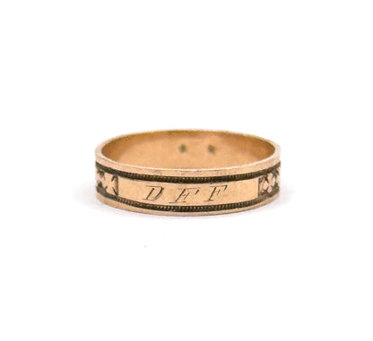 The band stands upright against white with the engraved initials "DFF" in the cartouche facing the camera, a clover motif at each side and the smooth inner shank visible above.