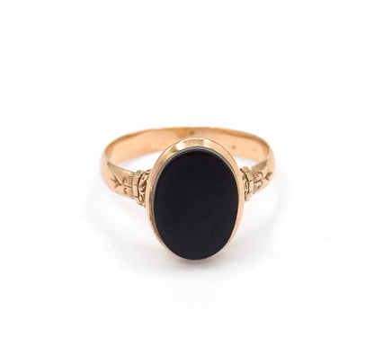 Upright and face-on against white, the oval banded agate centred in its yellow gold bezel with both engraved shoulders and the arch of the shank visible symmetrically behind.