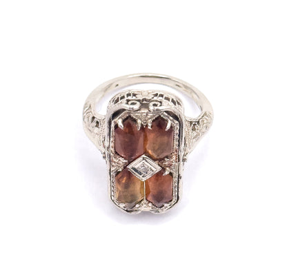 Straight-on view of the citrine side, showing the pierced scrollwork across the top of the gallery, the diamond-shaped centre setting, and the engraved shoulders flowing into the slim shank.