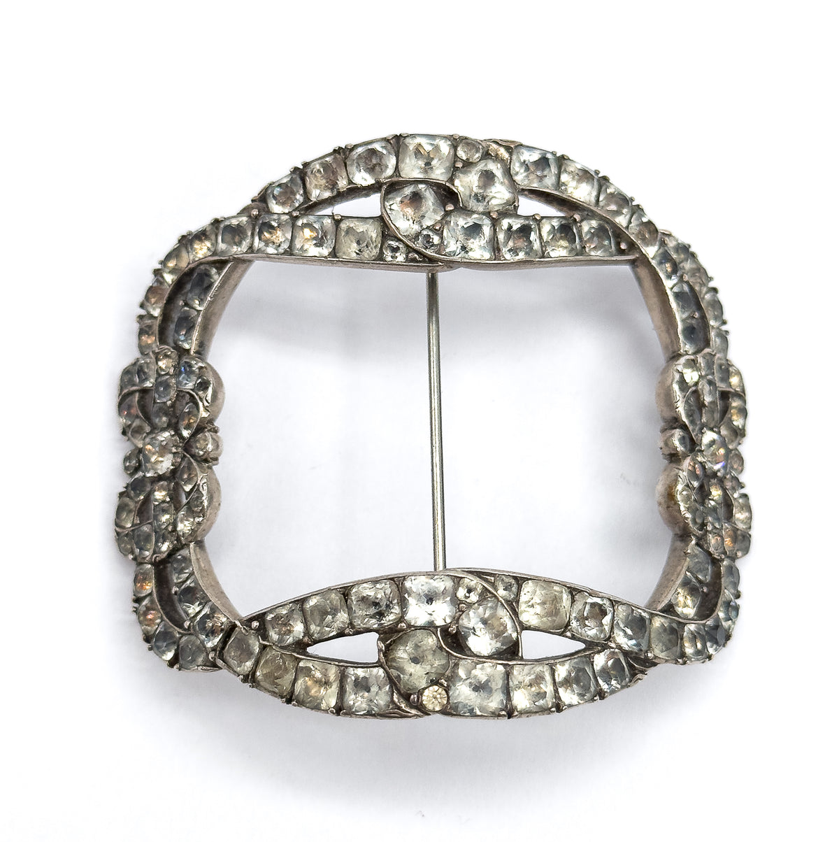 Straight-on front view of the full squared buckle brooch on white, the bow knots at top and bottom facing each other across the open centre with the slim pin stem running vertically between them.