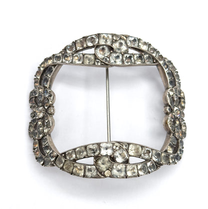 Straight-on front view of the full squared buckle brooch on white, the bow knots at top and bottom facing each other across the open centre with the slim pin stem running vertically between them.