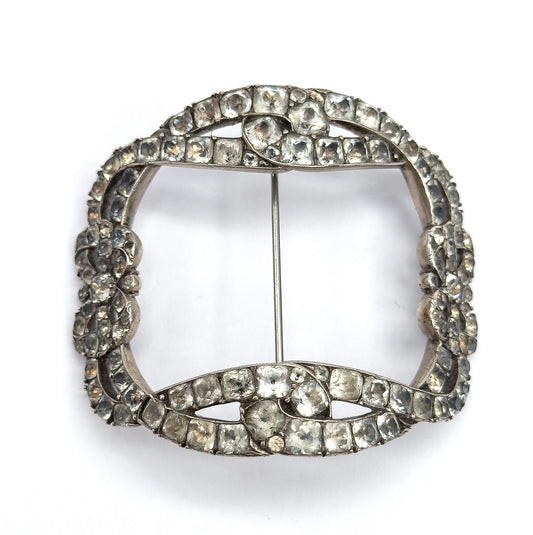 Straight-on front view of the full squared buckle brooch on white, the bow knots at top and bottom facing each other across the open centre with the slim pin stem running vertically between them.