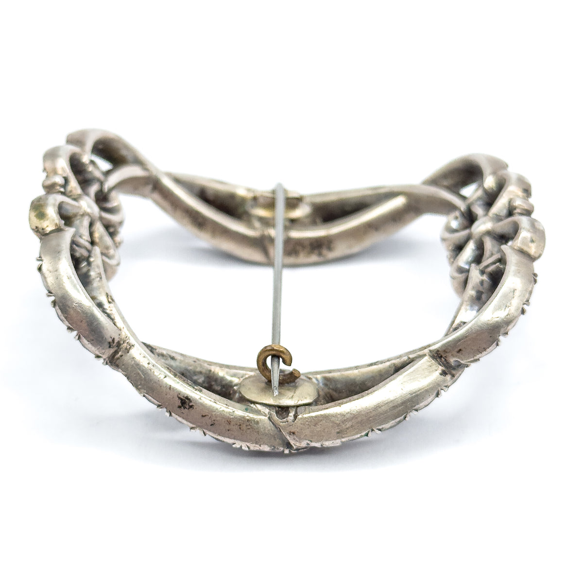 The reverse view on white, showing the smooth sterling silver back, the long pin stem crossing the open frame, and a small round catch fitting at the centre.