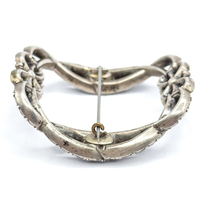 The reverse view on white, showing the smooth sterling silver back, the long pin stem crossing the open frame, and a small round catch fitting at the centre.