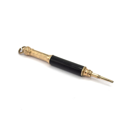 The whole pendant laid flat on white, angled from the suspension ring at upper left down to the tapered gold tone pencil tip extended at lower right.