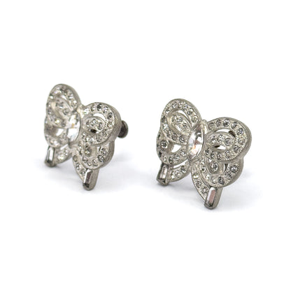 Both bows now face forward at a three-quarter angle, each marquise stone flashing at the centre of its ribbon loops with round stones along the curves and a baguette at each trailing end.