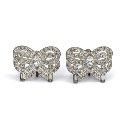 Both bows squared to the camera face-on, side by side, showing the full symmetry of each ribbon: marquise stone at the centre, round stones tracing the milgrain-edged loops, baguette at each end.