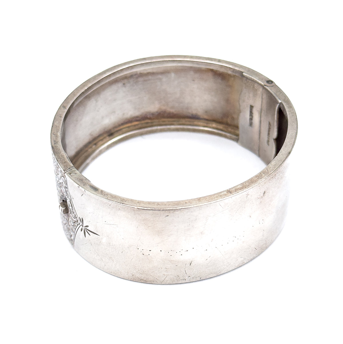The whole cuff stood upright and open, viewed from above and behind so the smooth interior and the box clasp opening at the right are both visible.