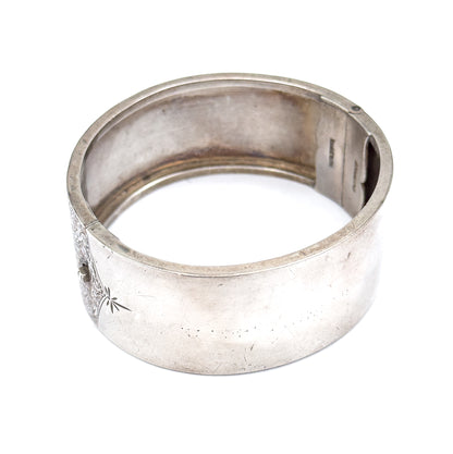 The whole cuff stood upright and open, viewed from above and behind so the smooth interior and the box clasp opening at the right are both visible.