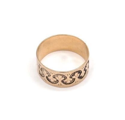 Almost the same view with slightly different angle, tipped further back so the open circle and smooth inner shank fill the top, with the trefoil pattern running along the band below.