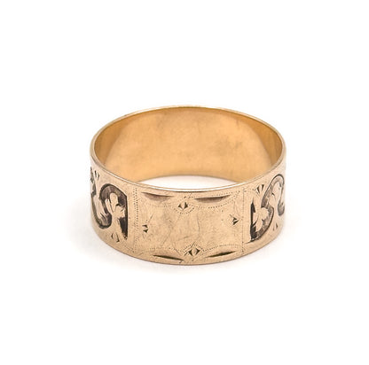 Straight-on front view with the small engraved cartouche panel centred on the wide band, a trefoil motif curving away at each side and the smooth inner shank visible above.