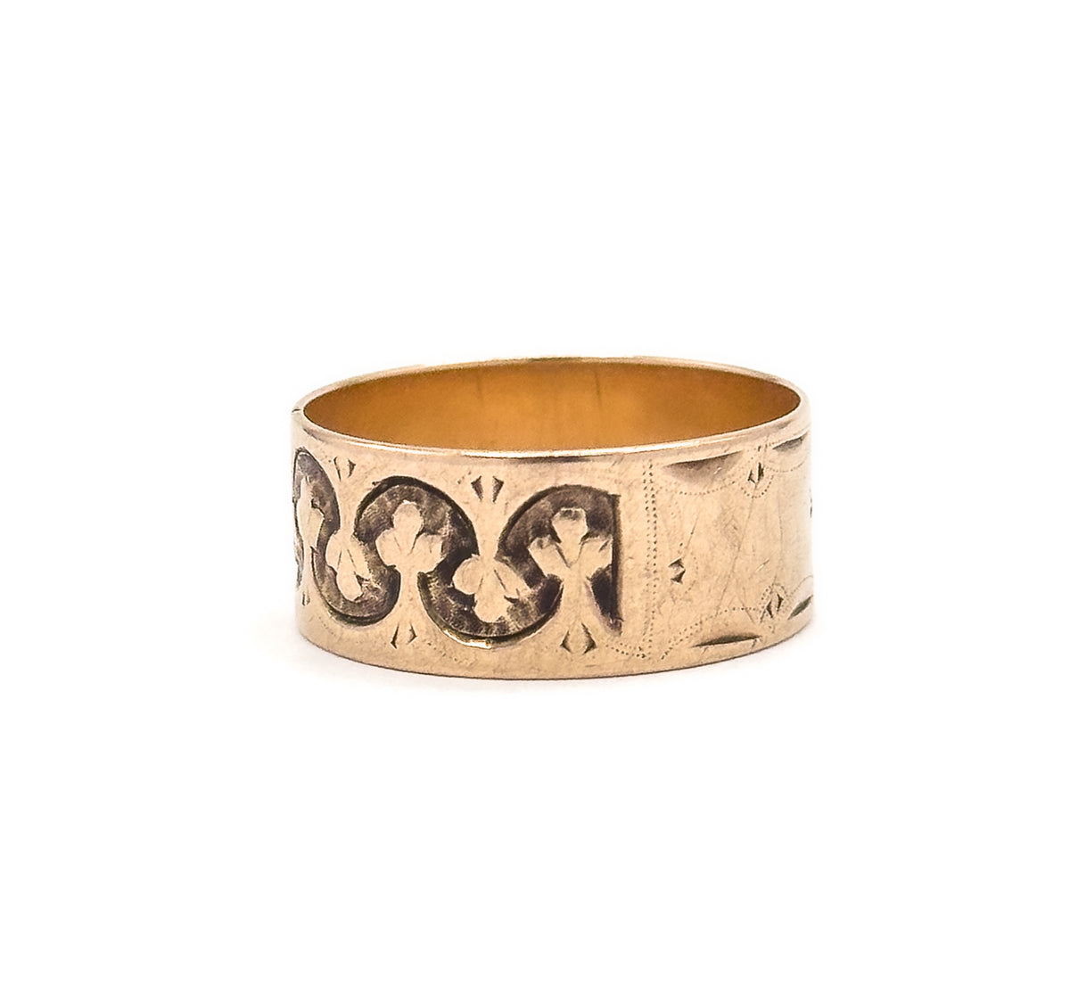 The band has rotated further so the linked trefoils now fill the left of the face while the plainer engraved cartouche section curves away to the right edge.