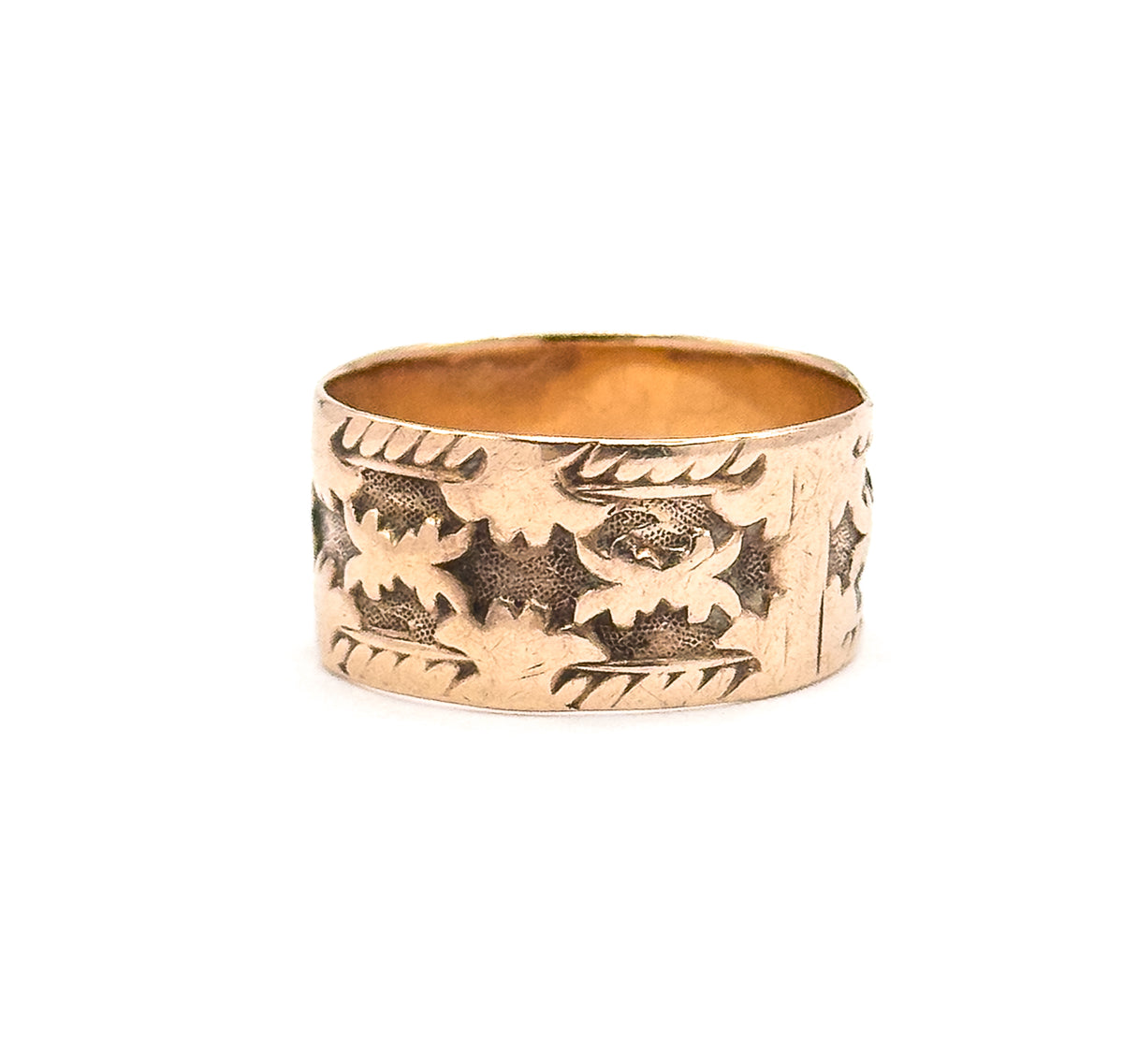 The band stands upright with only a narrow sliver of the interior visible at the top, the carved leaf motifs curving away around the side so the pattern is seen continuing round the back.