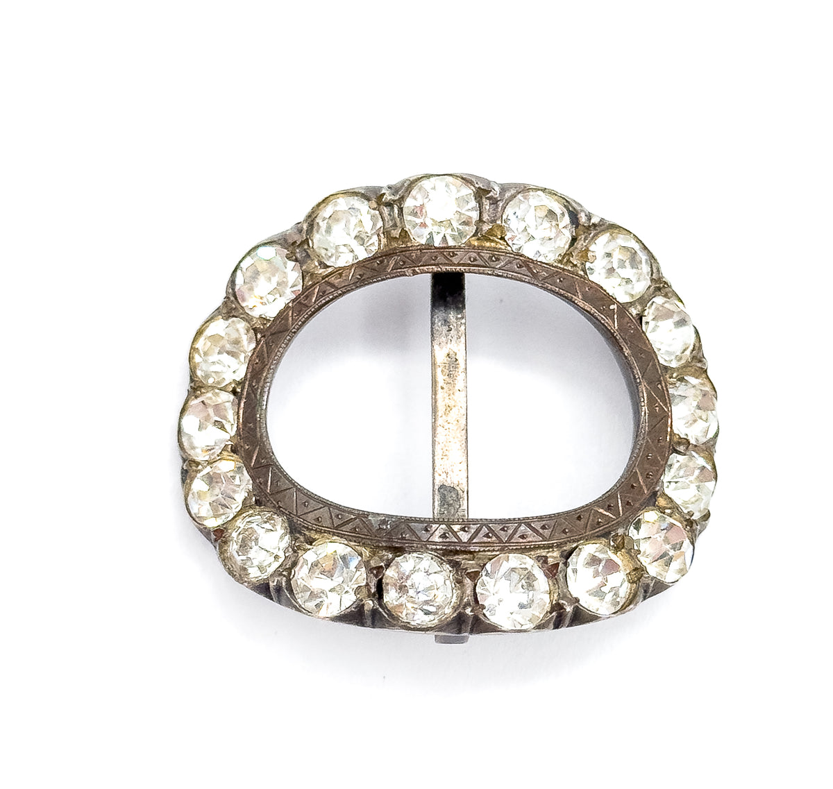 Straight-on flat view of the full oval, the vertical centre bar dividing the open middle and the zigzag hand-etched banding on the inner sterling silver frame clearly legible between the paste stones.