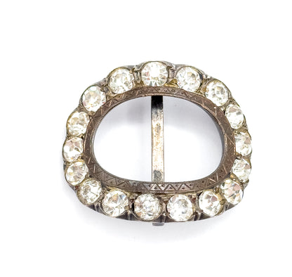 Straight-on flat view of the full oval, the vertical centre bar dividing the open middle and the zigzag hand-etched banding on the inner sterling silver frame clearly legible between the paste stones.