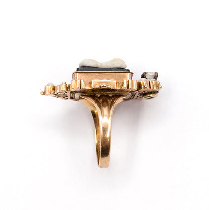 Victorian hardstone cameo, seed pearl and diamond ring in 9K rose gold, shown upright from the side so the tapering shank, raised bezel and stepped openwork gallery stand clear against white.