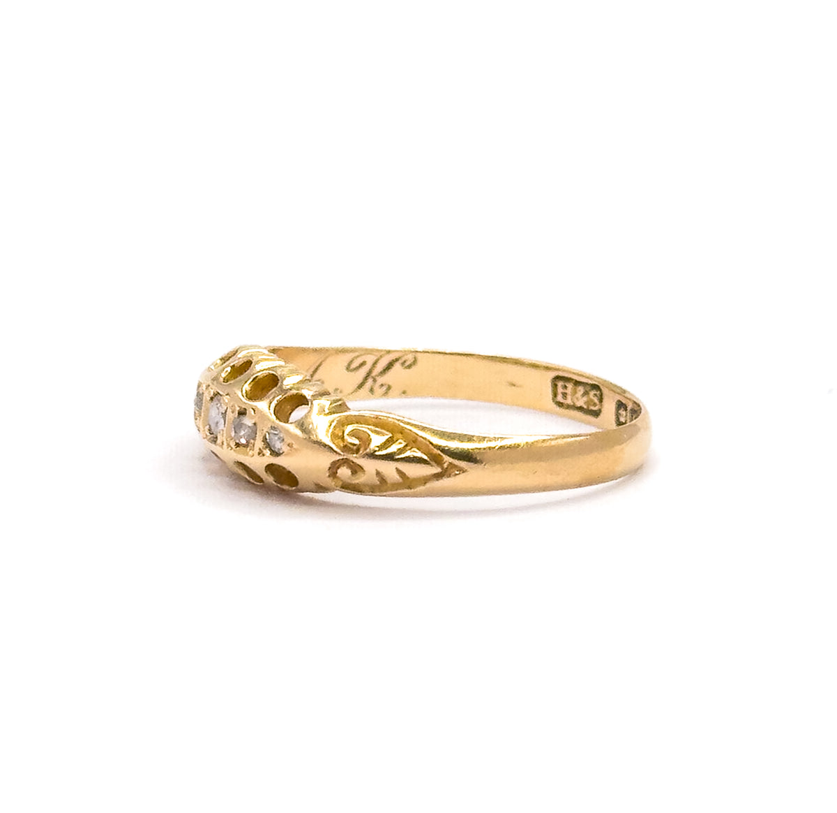 Opposite side profile on white, with the maker's mark "H&S" stamped on the inner shank and the flowing script engraving visible inside the band behind the diamonds.