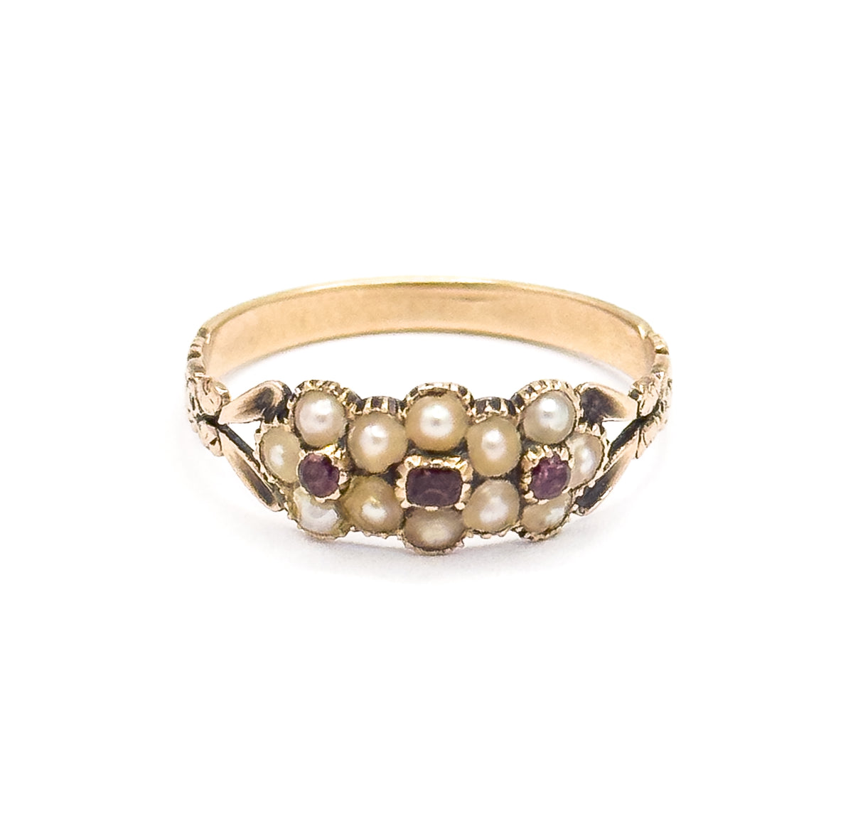 Upright front view against white, the face level with the camera so the split seed pearl flowers and three pinkish-purple tourmalines read across the setting above the plain band.